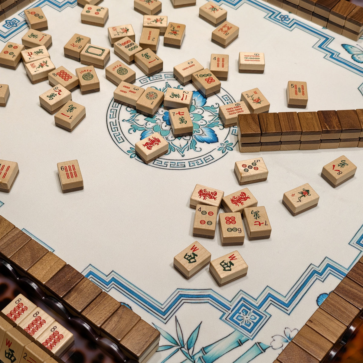 Wood Harmony wooden American Mahjong tiles scattered during play on a blue floral mat