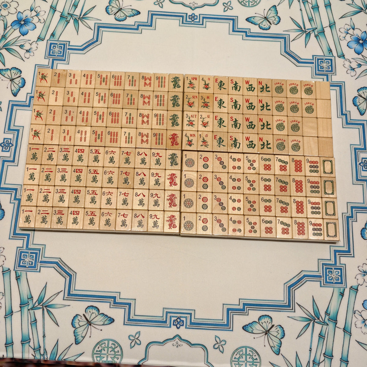 Full Wood Harmony wooden American Mahjong set arranged in rows on a blue floral mat