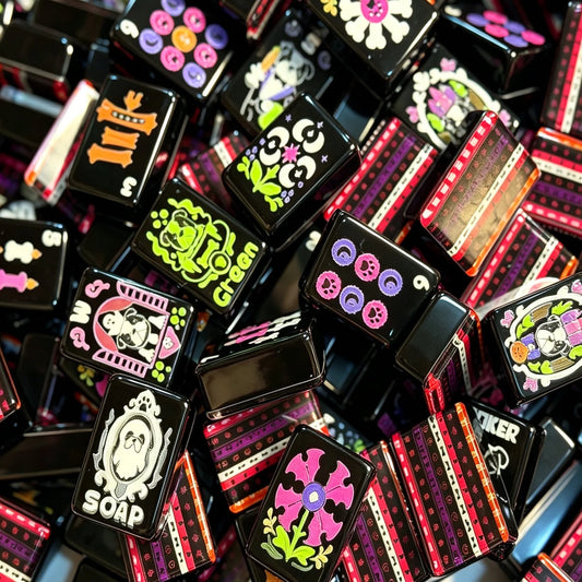 Haunted Hounds black Mahjong tiles scattered to show neon faces and striped multicolor backs